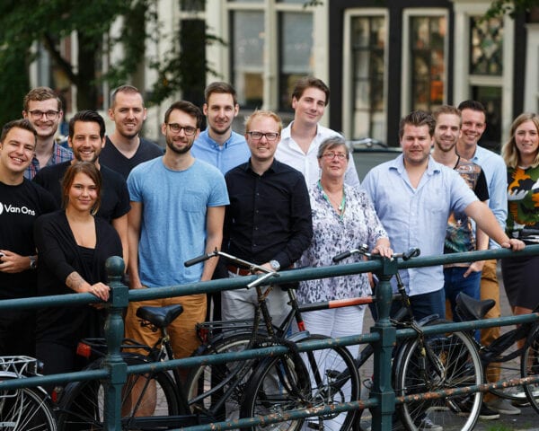 Het team van Van Ons op een brug in Amsterdam